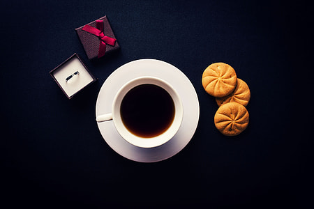 Overhead shot of coffee, biscuits and a ring thumbnail