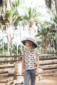 girl standing beside brown wood stump during daytime thumbnail