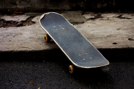 empty black skateboard on gray pavement thumbnail