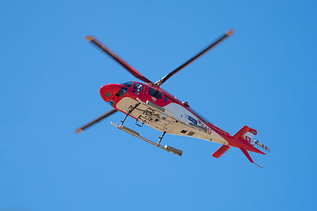 red and white helicopter under blue sky during daytime thumbnail