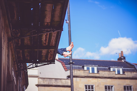 person sitting on silver roof during daytime thumbnail