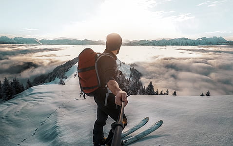 man riding ski on mountain hill watching aerial view on trees and mountain covered with snow during daytime thumbnail