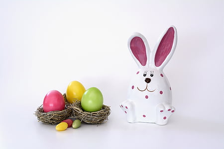 white and pink rabbit ceramic figurine beside Easter eggs thumbnail