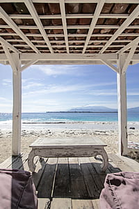 white wooden dock inside shed near body of water thumbnail