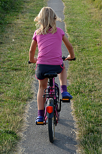 girl riding bicycle on narrow pathway thumbnail
