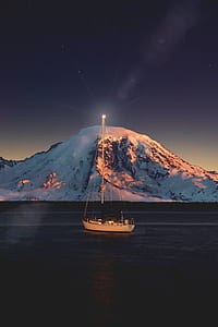 beige crew ship near snow covered mountain under stars thumbnail