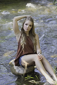 woman in red tank top sitting on brown stone thumbnail