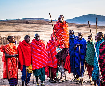 Photo of Group of Men Wearing Assorted Scarves Holding Sticks thumbnail