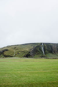 green grass field overlooking hill thumbnail