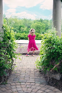 girl wearing pink sleeved dress standing on pathway thumbnail