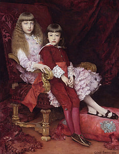 two girls sitting on armchair front of maroon textile thumbnail