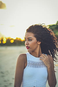 closeup photo of a woman holding her neck wearing white sleeveless shirt thumbnail