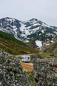 white RV near mountains during daytime thumbnail