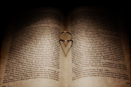 silver-colored ring between book forming heart shadow thumbnail