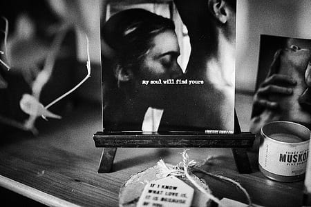 grayscale photography of woman kissing on man's back photo thumbnail