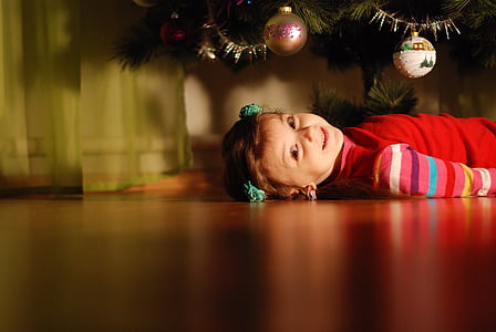 girl lying on the floor under Christmas tree thumbnail