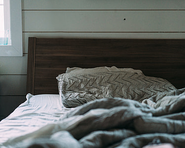 gray comforter near brown wooden bed headboard thumbnail