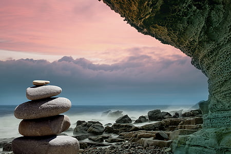 zen stone near rock formation and shore at daytime thumbnail