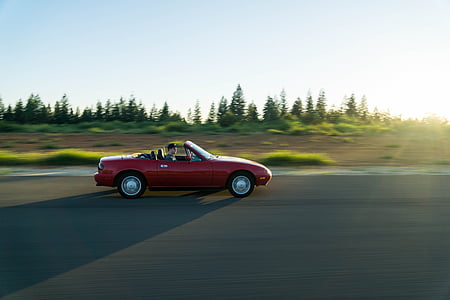 time lapse photo of man inside running convertible coupe during day thumbnail