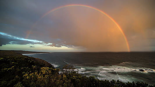 rainbow at distance over sea thumbnail