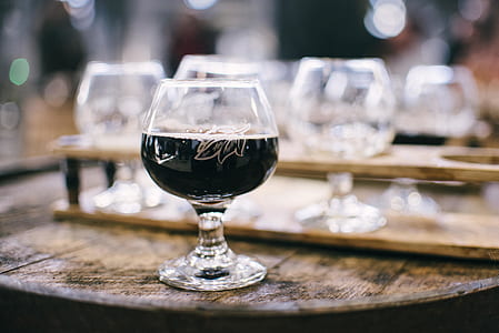 clear wine glass with black liquid in focus photography thumbnail