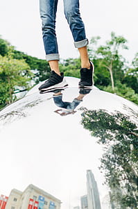 person wearing black sneakers standing on stainless steel ball thumbnail