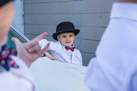 boy wearing black fedora hat beside gray cinder brick wall thumbnail