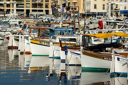 assorted boats park across brown concrete building thumbnail