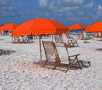 deck hairs and umbrellas at the beach during day thumbnail