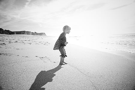 child walking on seashore during daytime thumbnail