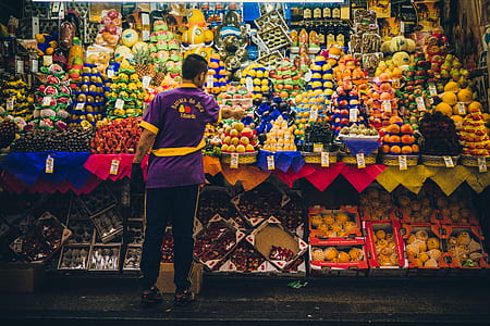 man standing in front of fruit stand thumbnail