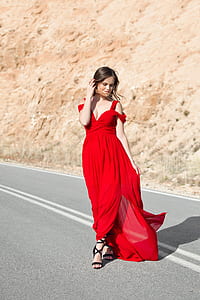 woman wearing red tank dress standing at asphalt road thumbnail