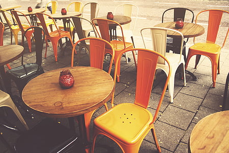 round brown table beside two orange chairs thumbnail
