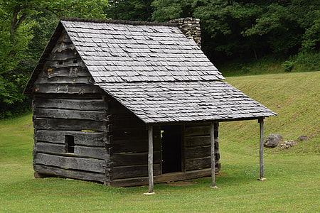 brown wooden shed surrounded by green leaf trees thumbnail