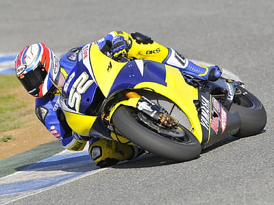 person riding yellow and blue sports bike thumbnail