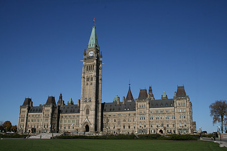 brown concrete building with teal spire under blue sky at daytime thumbnail