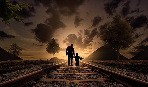 silhouette photo of two person walking on train rail during golden hour thumbnail