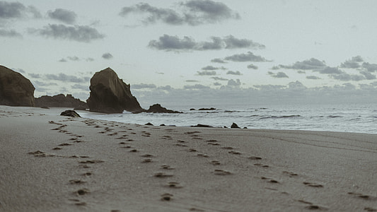footsteps on beach during daytime thumbnail