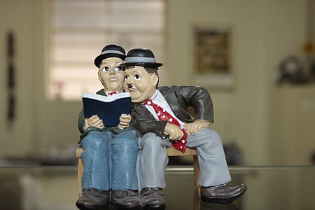 man sitting beside man while holding book thumbnail