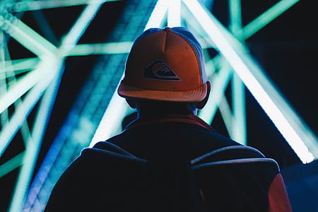man wearing black and white Quiksilver cap facing lighted building thumbnail