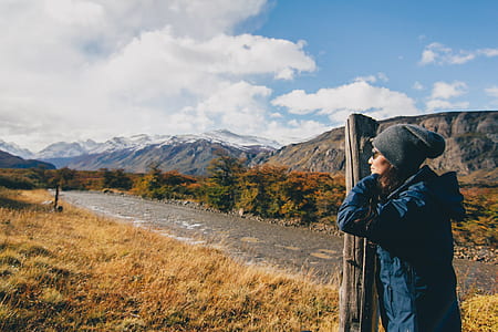 person standing beside brown post during daytime thumbnail