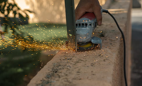 person cutting gray metal using corded angle grinder thumbnail