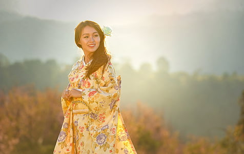 selective focus photography of woman wearing yellow and green floral long-sleeved traditional dress thumbnail