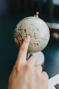 Male Finger Showing A Part Of The World On An Globe thumbnail