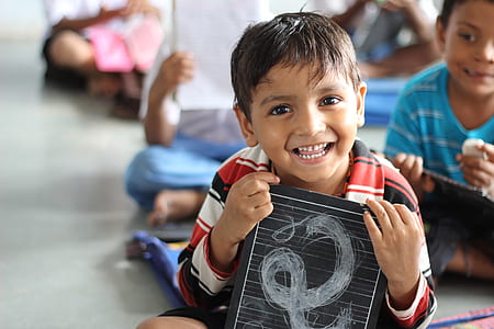 boy holding a black board smiling thumbnail