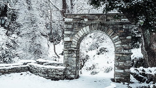 brown concrete arch gate covered with snow thumbnail