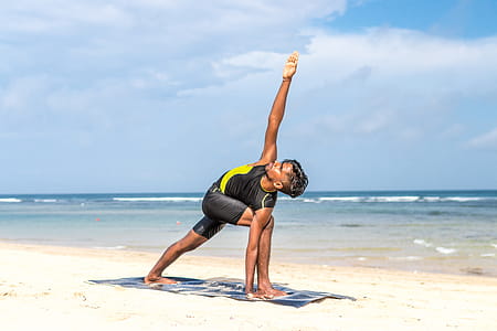 Man Doing Yoga Pose on Blue Mat Beside Seashore thumbnail