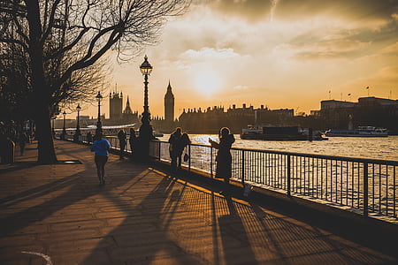 people standing road beside body of water with railings thumbnail