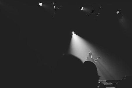 man playing guitar in stage with spotlight thumbnail