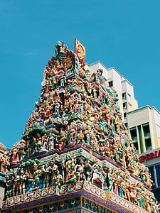 god statuette tower under blue sky thumbnail